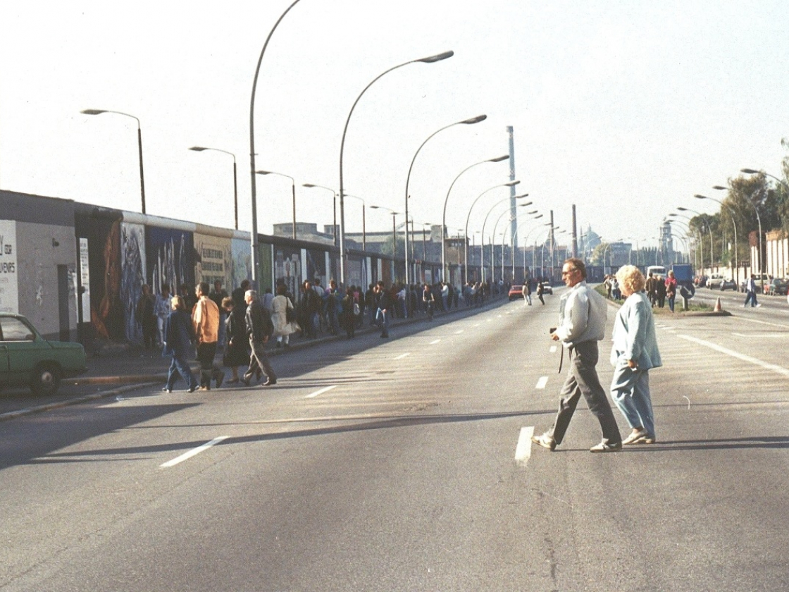 Personen spazieren auf der Straße an der East Side Gallery